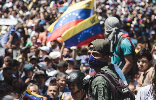 Militer Venezuela, berjaga di tengah massa pendukung pemerintah dan kubu opisisi, di Caracas, Rabu (1/5/2019). (Twitter)