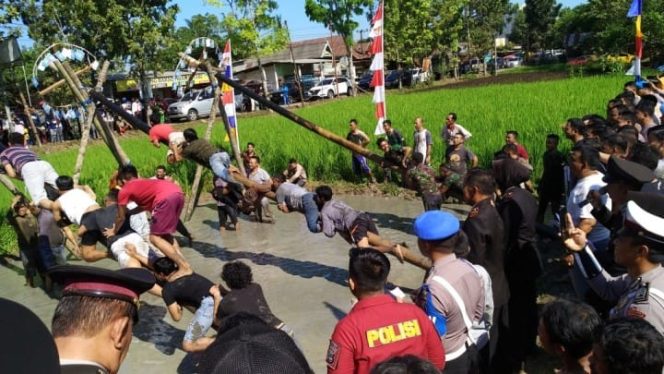 					Beberapa warga dan Personel yang ikuti lomba Panjat Pinang di HUT Bhayangkara ke-73.(Berita.news/Abdul Kadir). 