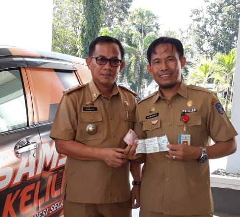 Staf Pelayanan di UPT. Pendapatan Samsat Takalar, H. Alimuddin Daeng Liwang bersama memberikan STNK Camat Galsel setelah bayar PKB. (BERITA.NEWS/Hasrullah).