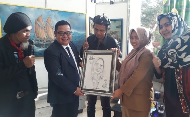 					Pemberian cendera mata kepada Kepala Dinas Pariwisata Kota Makassar, Rusmayani Madjid oleh seniman karikatur, Faisal Uwa di Hotel Aryaduta Makassar, Selasa (13/8/2019). (BERITA.NEWS/Ratih Sardianti Rosi). 