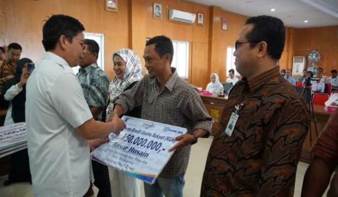 					Tomy Satria Yulianto menyerahkan secara simbolis kepada pelaku usaha yang mendapatkan bantuan kredit. (BERITA.NEWS/IL). 