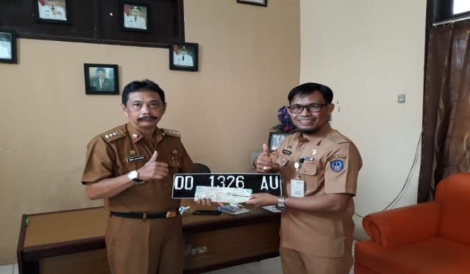 					Camat Pattallassang, Abd Salam Gau (Kanan) saat staf pelayanan UPT. Pendapatan Samsat Wilayah Takalar, H. Alimuddin Daeng Liwang (Kiri) membawakan STNK dan Plat Mobi. (BERITA.NEWS/Abdul Kadir). 