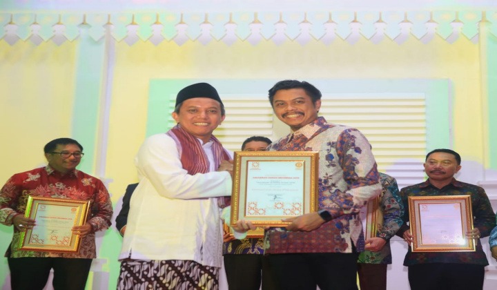 Founder & CEO Humas Indonesia Asmono Wikan (kiri) saat memberikan penghargaan kepada Kabag Humas Setda Kota Makassar Firman Hamid Pagarra (kanan) pada kompetisi AHI di Balai Kota Tangerang. (BERITA.NEWS/Ratih Sardianti Rosi).