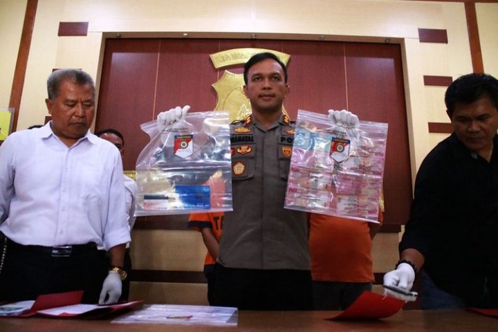 Kapolres Ngawi AKBP Pranatal Hutajulu memperlihatkan sejumlah barang bukti kasus pemerasan dengan modus postingan foto bugil di media sosial. (FOTO KOMPAS.COM)