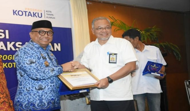 					Kepala Dinas Perumahan, Kawasan Permukiman dan Pertanahan Kabupaten Gowa, Abdullah Sirajuddin saat menerima piagam penghargaan. (BERITA.NEWS/ACP). 