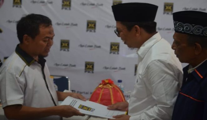 					Tommy menggunakan kopiah menyerahkan berkas pendaftaran ke pengurus PKS. (BERITA.NEWS/IL). 