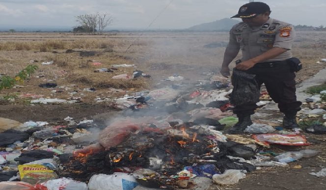 					Aipda Musafir saat membersihkan dan membakar sampah dipinggir Jalan Desa Paenre Lompoa. (BERITA.NEWS/IL). 