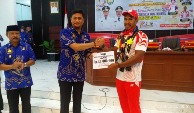 					Bupati Gowa, Adnan Purichta Ichsan saat memberikan penghargaan kepada Anwar Tarra, Atlet Dayung Asal Gowa. (BERITA.NEWS/Putri). 