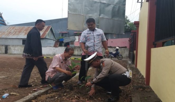 					Kanit Regident Polres Jeneponto, IPTU Aldiansyah berseragam polisi jongkok tanam pohon. (BERITA.NEWS/Muh Ilham). ﻿
