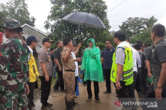 					Presiden Jokowi nampak menggunakan jas hujan plastik saat meninjau lokasi tersampak longsor di Desa Harkat Jaya, Kecamatan Sukajaya, Kabupaten Bogor, Jawa Barat, Selasa (7/1/2020). (ANTARA/M Fikri Setiawan)