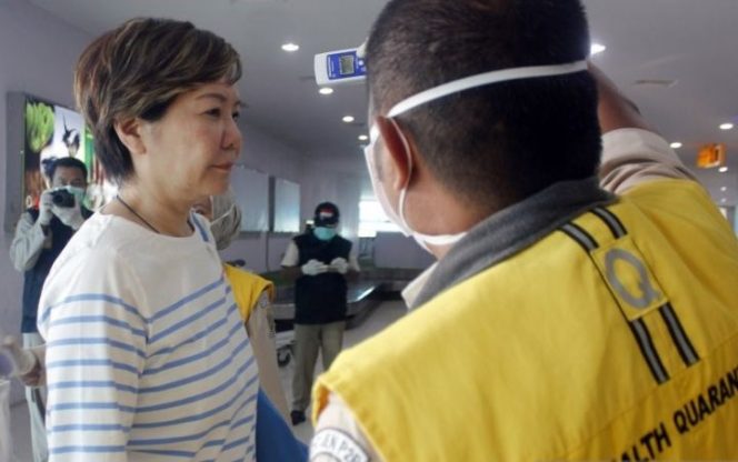 					Petugas Karantina Kesehatan memeriksa suhu tubuh wisatawan asal China (kiri) yang baru mendarat di bandara DEO Kota Sorong, Papua Barat, Ahad (26/1/2020). Otoritas Bandara dan Karantina kesehatan melakukan antisipasi penyebaran virus Corona (nCoV) terhadap Warga Negara Asing (WNA) asal Cina dengan menyiapkan alat pendeteksi suhu badan. (Antara)