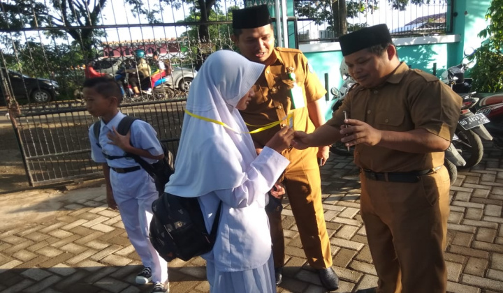 Kepala MTsN Gowa, Zulfikah Nur memantau langsung penggunaan absensi berbarkode didampingi salah seorang guru TIK, Marwan. (Foto: BERITA.NEWS/Putri).