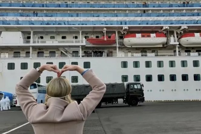 					Presiden Princess Cruises Jan Swartz membentuk hati dengan kedua tangannya ke arah kapal pesiar Diamond Princess, saat penumpang turun dari kapal setelah karantina, akibat penularan virus korona baru (COVID-19) di dermaga di Yokohama, Jepang, Kamis (20/2/2020), dalam gambar yang didapatkan dari video di media sosial. (PRINCESS CRUISES via REUTERS/PRINCESS CRUISES)