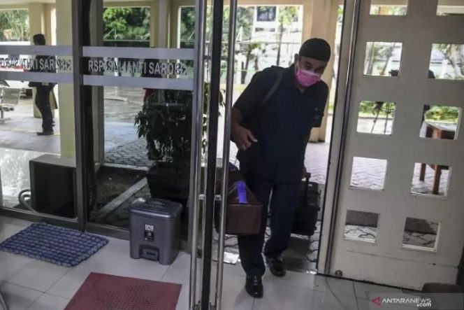 					Arsip Foto - Petugas membawa barang milik warga yang terduga terinfeksi virus COVID-19 kedalam Pos Pemantauan virus COVID-19 di RSPI Prof. Dr. Sulianti Saroso, Sunter, Jakarta Utara, Rabu (4/3/2020). ANTARA FOTO/Muhammad Adimaja/ama.