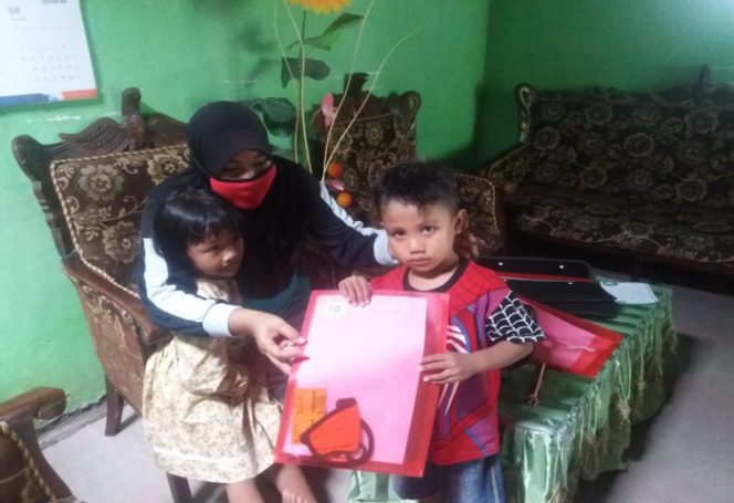 					salah satu guru TK Negeri Pertiwi Ranting Letta menyerahkan modul di rumah anak didiknya. (BERITA.NEWS/Saharuddin). 