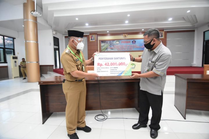 Wakil Bupati Gowa, Abd Rauf Malaganni saat menerima dana santunan kematian dari Badan Penyelenggara Jaminan Sosial Ketenagakerjaan (BP-Jamsostek) di Baruga Karaeng Galesong. (Foto: ist).