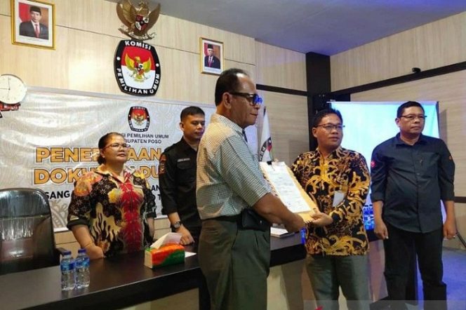 					Bakal pasangan calon bupati Poso Samsuri (kiri) menerima berkas dari Ketua KPU Kabupaten Poso Budimam Maliki (kanan) di Poso, Kamis (20/8/2020). (ANTARA/Feri Timparosa)