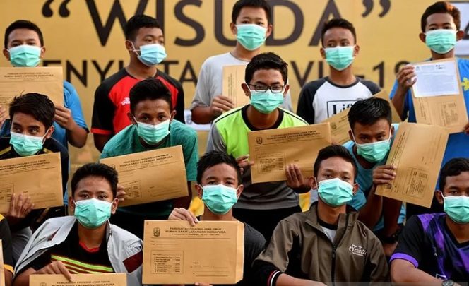 					Sejumlah santri asal Ponpes Gontor berpose ketika mengikuti wisuda penyintas COVID-19 di halaman Rumah Sakit Lapangan Surabaya, Jawa Timur, Selasa (28/7/2020). ANTARA FOTO/Zabur Karuru/hp/aa.