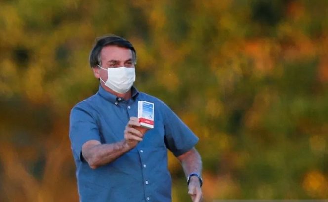 					Presiden Brazil Jair Bolsonaro membawa sekotak klorokuin di depan Istana Alvorada, di tengah wabah penyakit virus corona (COVID-19) di Brasilia, Brazil, Kamis (23/7/2020). ANTARA FOTO/REUTERS/Adriano Machado/foc/djo