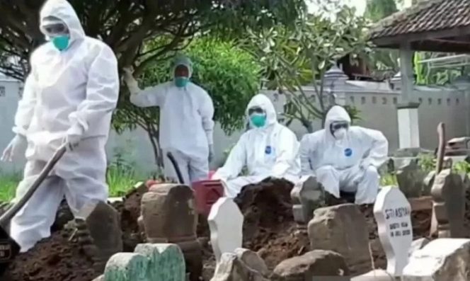 					Ilustrasi - Petugas memakamkan pasien terkorfirmasi positif corona warga Kecamatan Geger, Kabupaten Madiun, Jatim, yang meninggal dunia sesuai protokol kesehatan penanganan COVID-19. (ANTARA Jatim/Louis Rika/Tv)