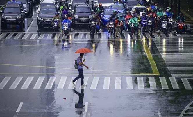 					Dokumentasi - Seorang warga menggunakan payung menyeberangi jalan saat hujan di kawasan Jalan MH Thamrin, Jakarta, Jumat (9/11/2018). ANTARA FOTO/Aprillio Akbar/hp.