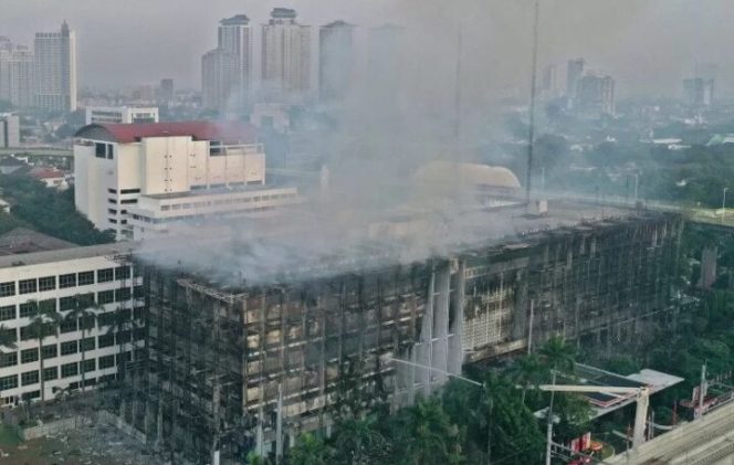 					Foto udara gedung utama Kejaksaan Agung yang terbakar di Jakarta, Minggu (23/8/2020). Kebakaran yang berawal sejak Sabtu (22/8) malam itu masih dalam penanganan pihak pemadam kebakaran hingga Minggu pukul 06.00 WIB. ANTARA FOTO/Aditya Pradana Putra/foc.