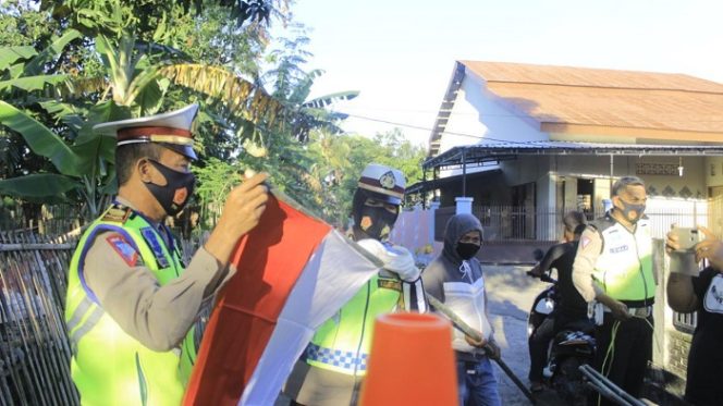 					Kasat Lantas Polres Pinrang AKP Dharmawaty SE MM dan anggotanya saat memasang bendera di rumah warga. ()