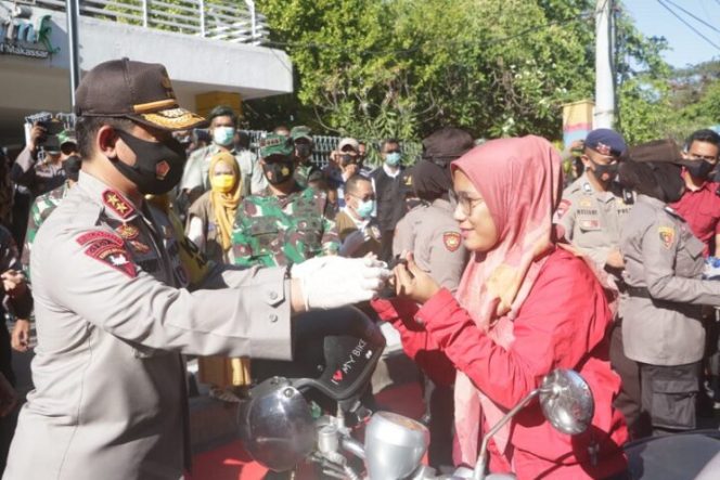 					Kapolda Sulsel Irjen Polisi Merdisyam menyerahkan masker kepada masyarakat pengguna jalan di depan lapangan Karebosi Makassar, Kamis (10/9/2020).