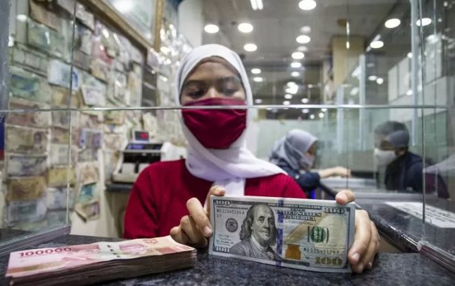 					Karyawan menghitung uang pecahan 100 dolar Amerika Serikat di salah satu gerai penukaran uang asing, di Jakarta, Selasa (29/9/2020). ANTARA FOTO/Dhemas Reviyanto/hp.