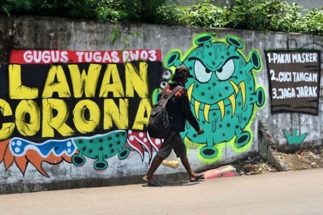 					Warga melintas di depan mural berisi ajakan melawan corona di Jalan Pahlawan Komarudin RW 03, Cakung Barat, Jakarta Timur, Sabtu (17/10/20). Visual karya Komunitas Bale Buku tersebut mengusung tema Sosialisasi Protokol Kesehatan 3M sebagai imbauan kepada masyarakat pentingnya protokol kesehatan memakai masker, menjaga jarak, dan mencuci tangan untuk mencegah penyebaran penularan COVID-19. (ANTARA FOTO/Suwandy)