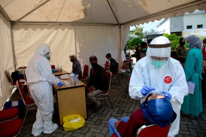 					Petugas melakukan tes antigen kepada pendatang di rest area, Kamis (24/12/2020). ()