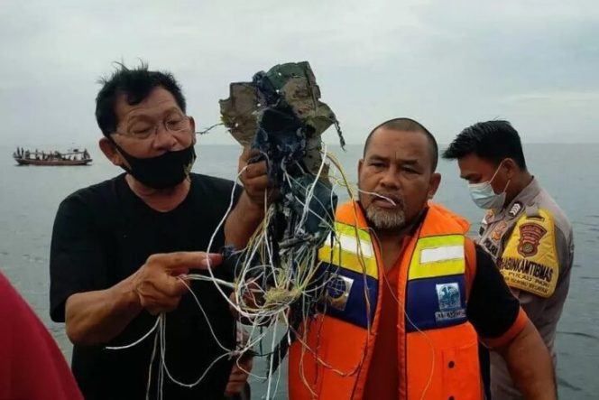					Petugas menunjukkan kabel dan serpihan yang diduga milik pesawat Sriwijaya Air di Pulau Laki, Kepulauan Seribu, Sabtu (9/1/2021). ANTARA/HO-Aspri.