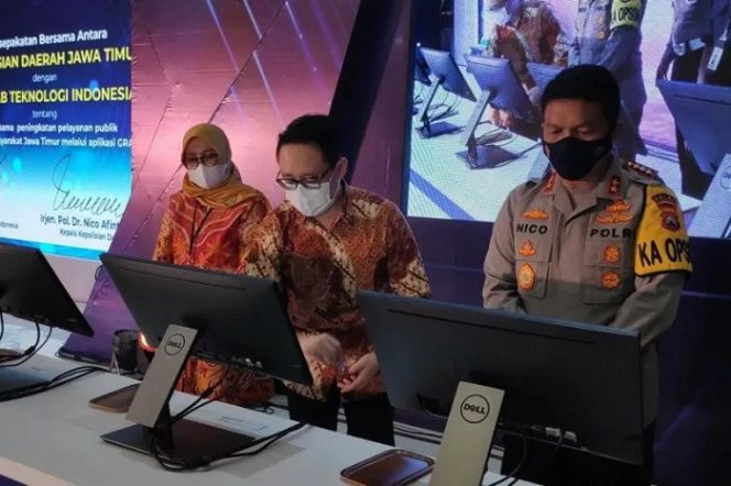 					Director of East Indonesia, Grab Indonesia Halim Wijaya (tengah) bersama Kapolda Jatim Irjen Pol Nico Afinta (kanan) menandatangani kerja sama dalam meluncurkan inovasi Online Delivery untuk perpanjangan Surat Izin Mengemudi (SIM) yang terintegrasi dalam aplikasi ‘Base Traffic Semeru’ milik Polda setempat di Surabaya, Selasa (23/3). (ANTARA Jatim/HO/WI)