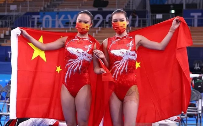 					Pesenam China Zhu Xueying (kiri) peraih medali emas senam indah trampolin perorangan putri Olimpiade Tokyo 2020 berpose bersama rekan senegaranya Liu Lingling yang memperoleh perak mengusung bendera China di Ariake Gymnastics Centre, Tokyo, Jepang, Jumat (30/7/2021). ANTARA/REUTERS/Mike Blake.