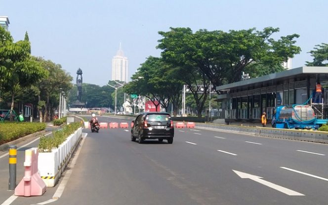 					Sejumlah kendaraan bermotor melintas di Jalan Sudirman yang dialihkan menuju Jalan Senopati-Jalan Patimura karen jalur menuju Bundaran Senayan ditutup sementara memasuki hari ketiga PPKM Darurat, Senin (5/7/2021). (ANTARA/Dewa Ketut Sudiarta Wiguna)