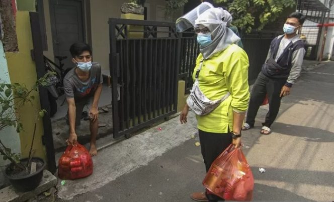 					Petugas memberikan paket bahan pokok ke warga yang menjalani isolasi mandiri di Jalan As-Syafiiyah, Cipayung, Jakarta, Jumat (21/5/2021). Sebanyak 25 paket bahan pokok dari bantuan Dinas Sosial DKI Jakarta dan swadaya masyarakat diberikan kepada warga yang isolasi mandiri sebagai bentuk kepedulian. ANTARA FOTO/Asprilla Dwi Adha/rwa.