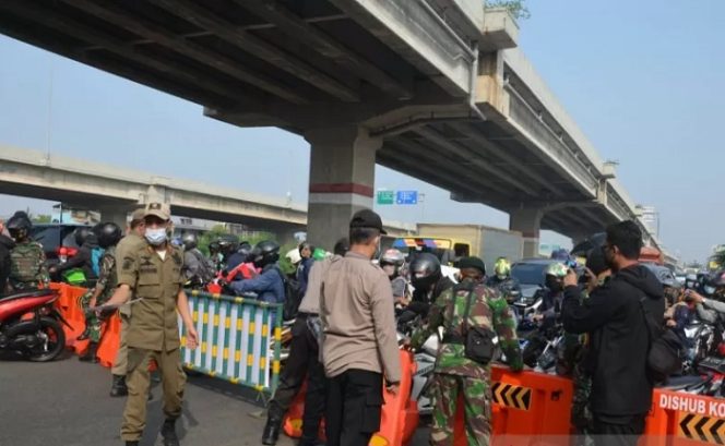 					Petugas gabungan membuat barikade saat memeriksa kelengkapan dokumen pemotor yang hendak menuju wilayah Kota Bekasi, Jawa Barat di pos penyekatan Sumber Arta Kalimalang, Kecamatan Bekasi Barat, Senin (5/7). (ANTARA/Pradita Kurniawan Syah)