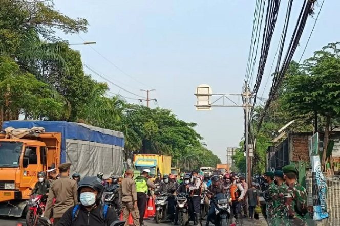 					Situasi penyekatan di jalan Daan Mogot kilometer 11 Jakarta Barat pada hari pertama perpanjangan PPKM, Rabu (21/7/2021). (ANTARA/Walda Marison)