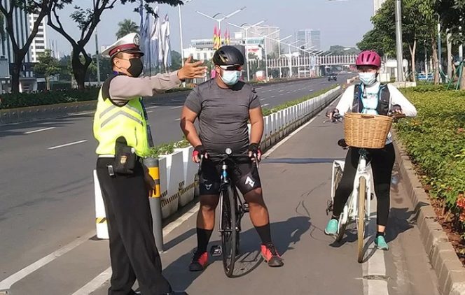 					Polisi memberhentikan pesepeda di jalur sepeda permanen pada hari pertama PPKM Darurat di di Jalan Sudirman, Jakarta, Sabtu (3/7/2021). ANTARA/Dewa Ketut Sudiarta Wiguna/aa.