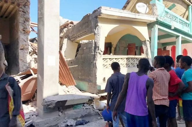 					Warga melihat bangunan yang runtuh akibat gempa di Jeremie, Haiti, Sabtu (14/8/2021). (Twitter @JCOMHaiti via Reuters)