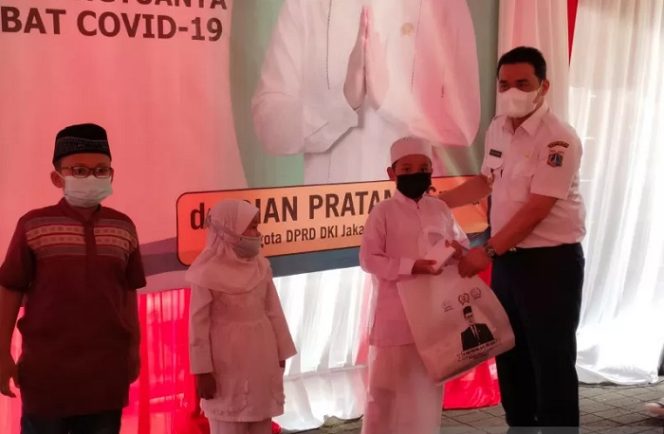 					Wakil Gubernur DKI Jakarta Ahmad Riza Patria menyerahkan bantuan kepada 200 anak yatim piatu karena COVID-19 di Jalan Mardani Raya, Cempaka Putih, Jakarta Pusat, Kamis (19/8/2021). ANTARA/Mentari Dwi Gayati.