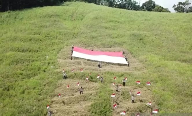 					Personel Polres Wondama membentangkan bendera merah putih berukuran besar di puncak gunung alang-alang Wasior menyambut HUT Ke-76 Kemerdekaan RI, Papua Barat, Minggu (15/8/2021). ANTARA/Ernes Broning Kakisina/aa.