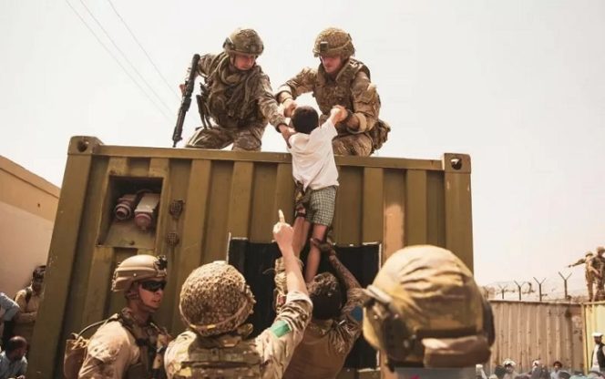 					Pasukan koalisi Inggris, koalisi Turki, dan Marinir AS mengawal seorang anak saat evakuasi di Bandara Internasional Hamid Karzai, Kabul, Afghanistan, dalam foto yang diambil Jumat (20/8/2021). Sgt. Victor Mancilla/U.S. Marine Corps/Handout via (Sgt. Victor Mancilla/U.S. Marine Corps/Handout viaREUTERS/AWW/djo)