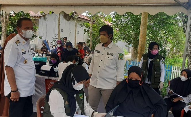 					Bupati Luwu Basmin Mattayang (kiri) sedang memantau vaksinasi, didampingi Kepala Desa Senga Selatan, Arfan Basmin (kanan).