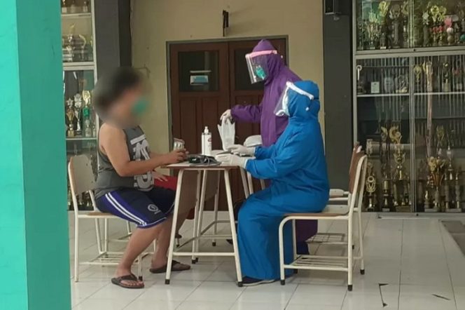 					Petugas kesehatan melakukan pemeriksaan kepada salah satu warga OTG tempat isolasi mandiri atau rumah sehat di SDN Tambaksari III, Kota Surabaya, Ahad (1/8/2021). ANTARA/HO-Humas Pemkot Surabaya.