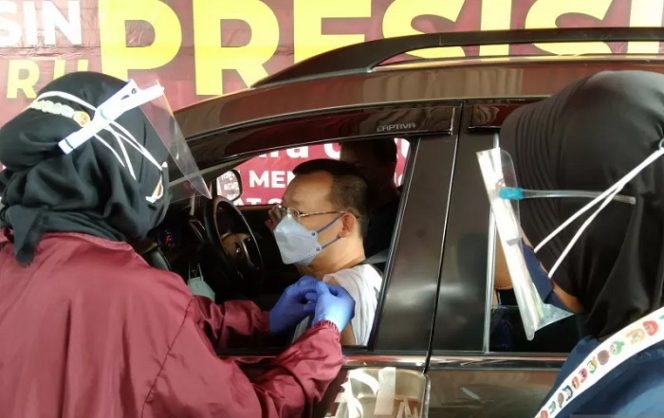 					Petugas medis menyuntikkan vaksin kepada pengendara melalui vaksinasi dengan layanan tanpa turun dari kendaraan yang diadakan Polres Metro Jakarta Selatan, Selasa (29/6/2021). (ANTARA/Dewa Ketut Sudiarta Wiguna)