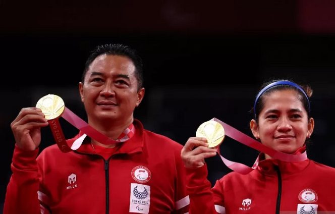 					Atlet para-badminton Hary Susanto bersama Leani Ratri Oktila berpose dengan medali emas usai menundukkan atlet para-badminton Prancis Lucas Mazur dan Faustine Noel pada final ganda campuran SL3-SU5 Paralimpiade Tokyo 2020 di Yoyogi National Stadium, Tokyo, Jepang, Minggu (5/9/2021). ANTARA FOTO/REUTERS/Athit Perawongmetha/rwa.
