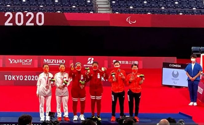 					Leani Ratri Oktila/Khalimatus Sadiyah (tengah) memperlihatkan medali emas setelah menang 21-18, 21-12 atas wakil China Cheng Hefang/Ma Huihui pada final ganda putri SL3-SU5 di Stadion Nasional Yoyogi, Jepang, Sabtu (4/9/2021). (ANTARA/HO-KBRI Tokyo)