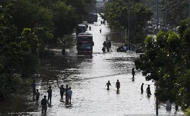 					Warga melintasi banjir di Jalan Pangeran Tubagus Angke, Jelambar, Jakarta, Kamis (2/1/2020). Banjir tersebut terjadi karena meluapnya Kali Angke. ANTARA FOTO/Hafidz Mubarak A/foc.