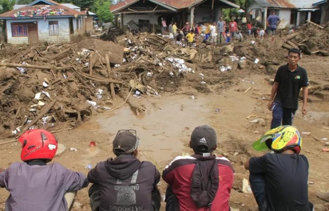 					ilustrasi. Sejumlah warga menyaksikan warga lain yang sedang membersihkan rumah mereka tertimbun lumpur akibat diterjang banjir bandang di desa Waiburak, Kecamatan Adonara Timur, NTT, Selasa (6/4/2021) ANTARA FOTO/Kornelis Kaha.